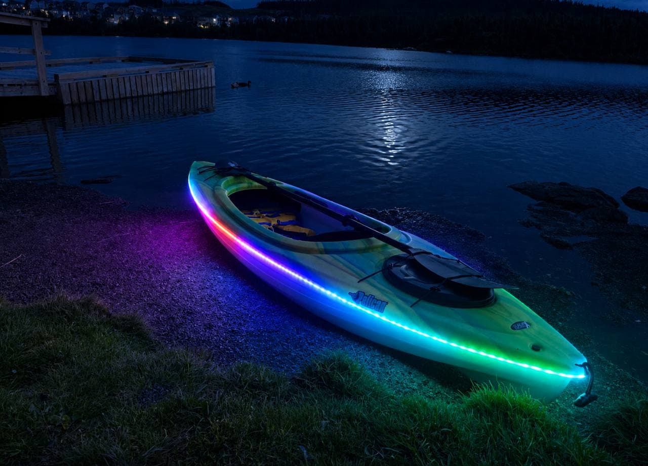An RGB LED illuminated kayak glowing on the shoreline at Neil's Pond.