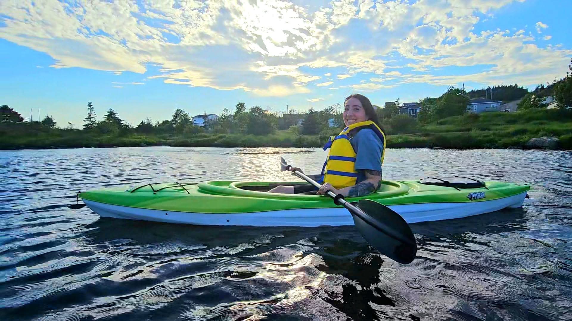 A paddler in a green kayak on Neil's Pond near St. John's, Newfoundland.
